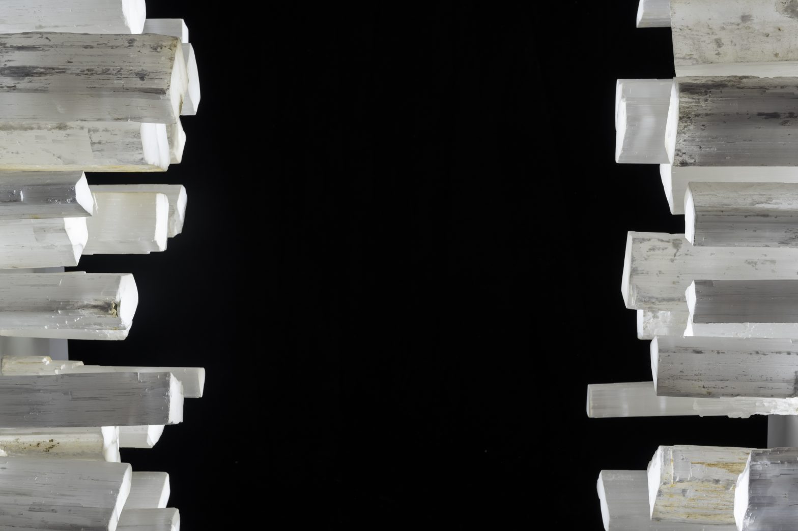 A black background, framed on either side with jagged white crystals in varying sizes