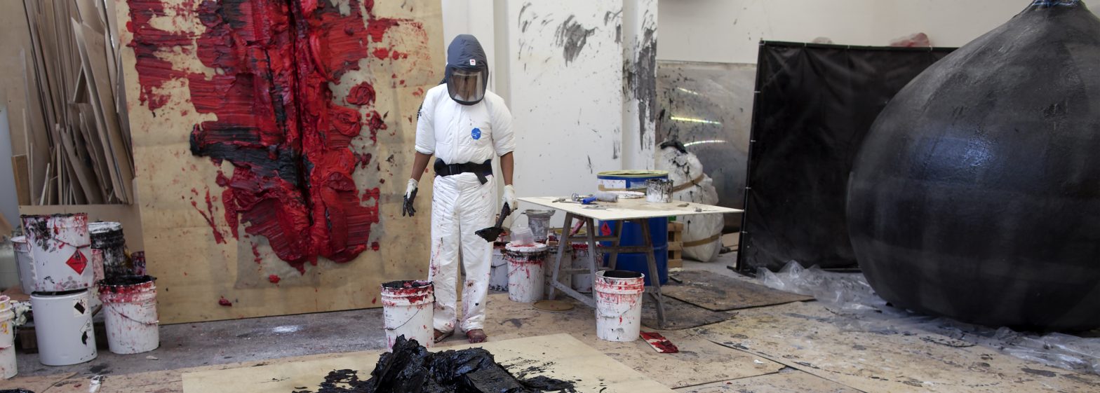 Artist Anish Kapoor making two new works in his Studio. One is on the wall behind him and the other on the floor in front of him