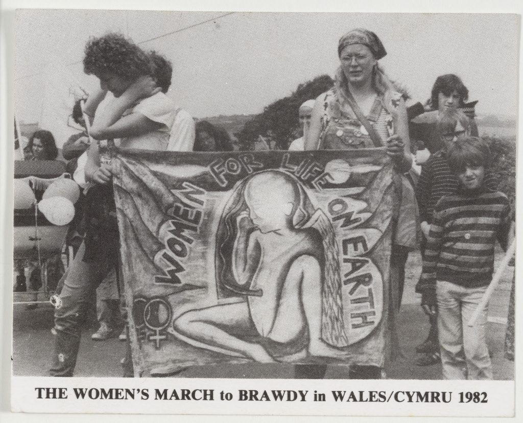 Monica Sjöö carries her painting 'Women For Life on Earth' as a banner whilst taking part in a protest march.