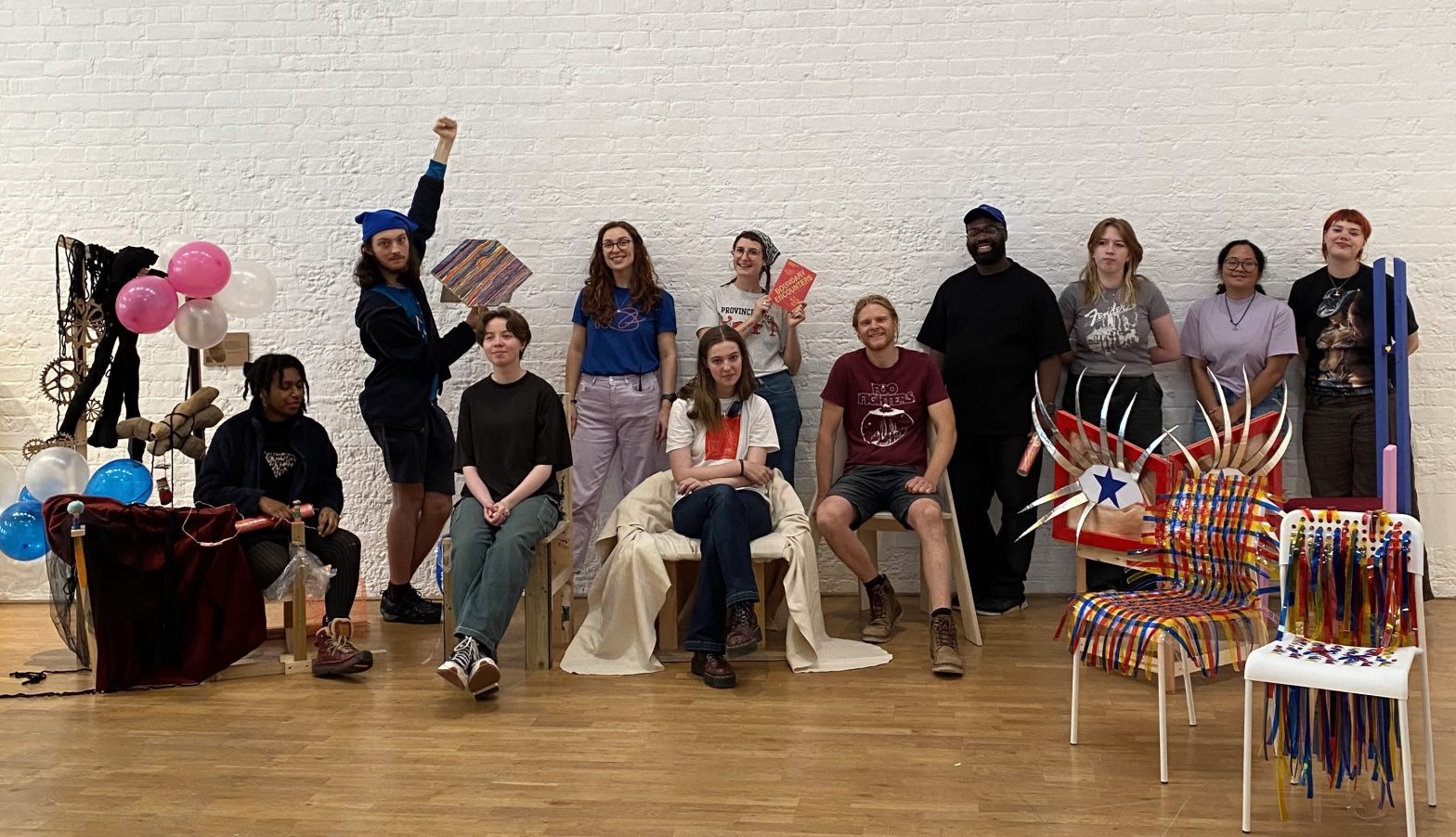 Photograph of Young Creatives at Boundary Encounter, posing with decorative chairs.