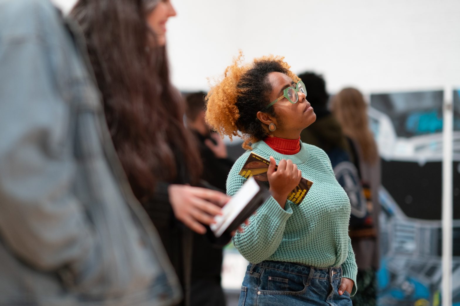 A visitor looks carefully at an artwork.