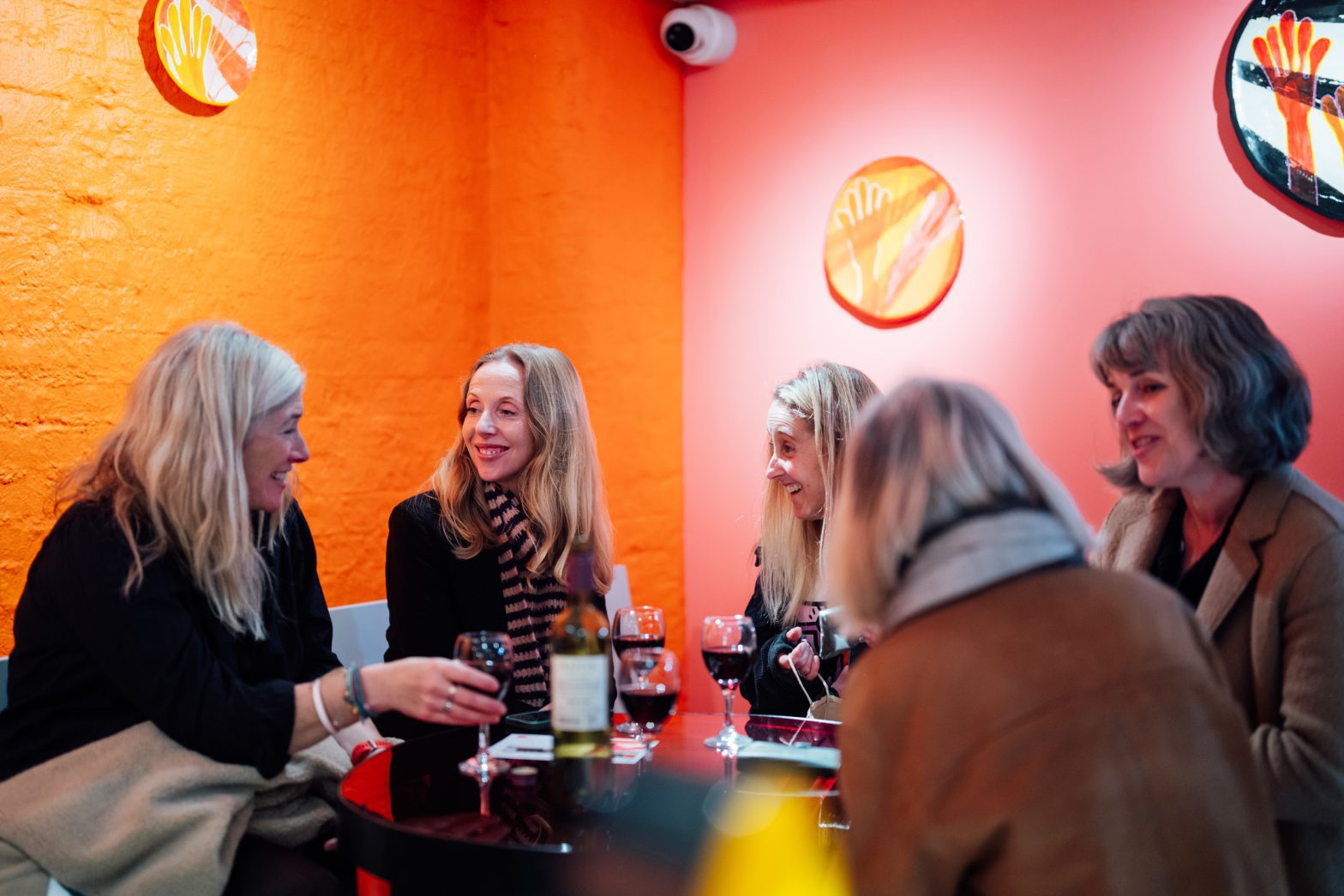 A large group sit laughing around a table.
