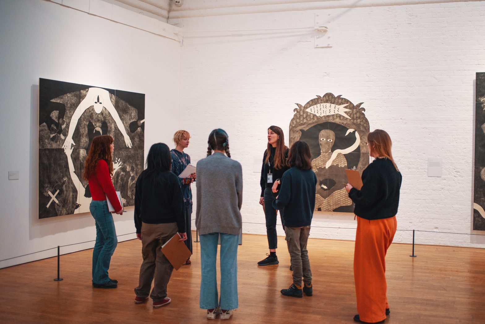 A group of Modern Art Oxford's Young Creatives are standing in a gallery on a tour.