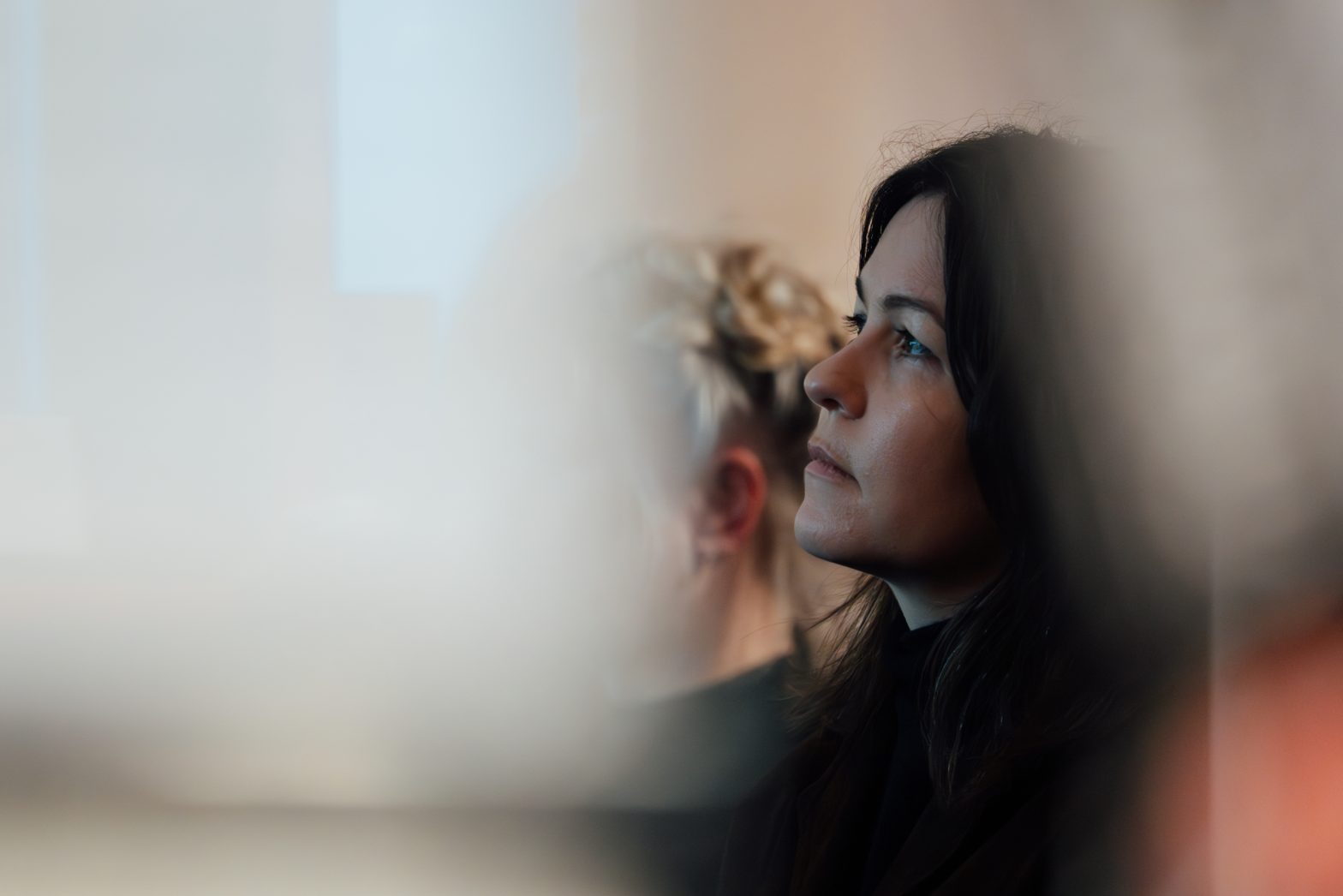 A woman listens carefully at a talk.