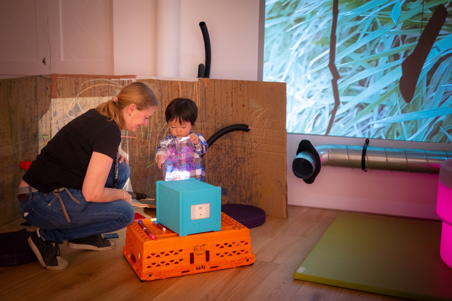 A woman and child explore an artwork together.