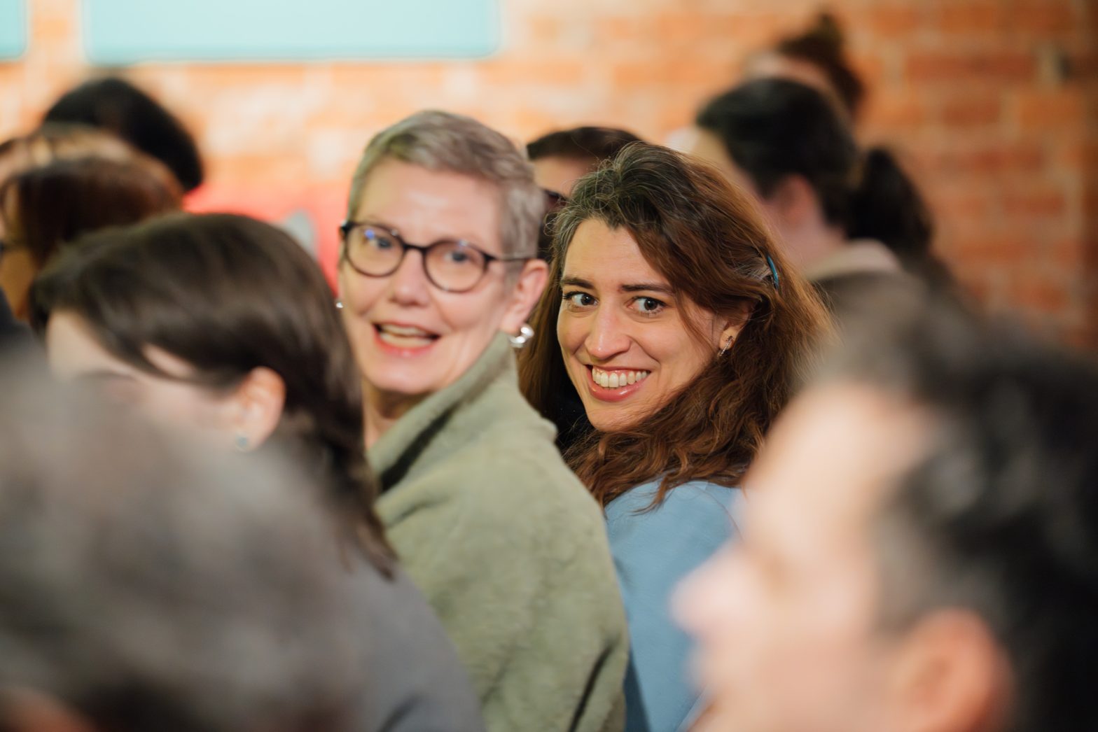 Two people sat in amongst an audience at Modern Art Oxford gallery.