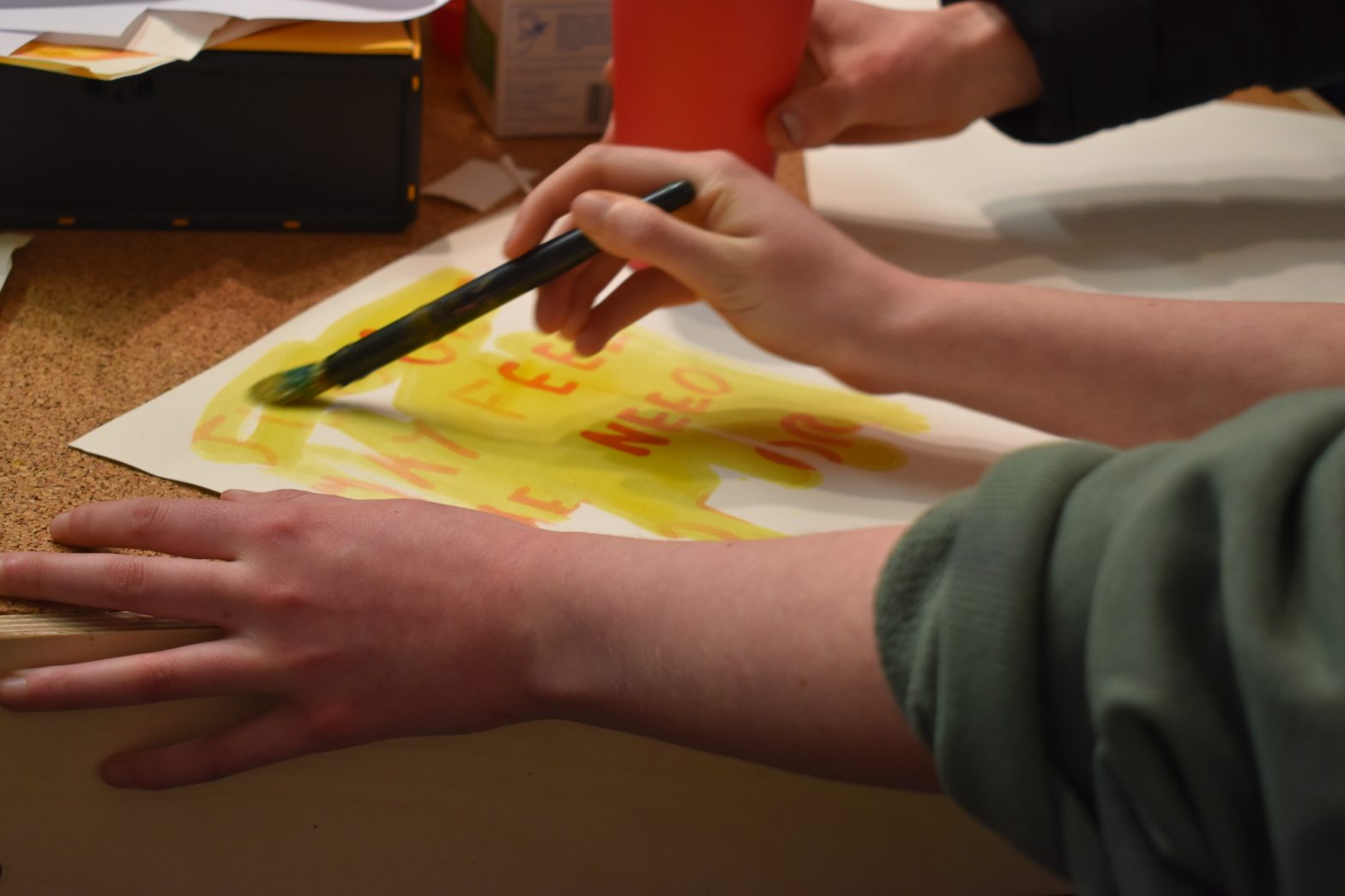 A photo of someone painting in a workshop using yellow ink.